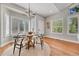 Cozy dining area featuring a round table, hardwood floors, and ample natural light through large windows at 5255 Ridge Trl, Littleton, CO 80123