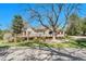 Beautiful home exterior with a spacious deck, lush lawn, and a lovely shade tree in the front yard at 5255 Ridge Trl, Littleton, CO 80123