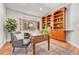 Comfortable home office featuring custom built-ins, a cozy seating area, and ample desk space at 5255 Ridge Trl, Littleton, CO 80123