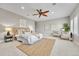 A primary bedroom with a ceiling fan, neutral walls, carpet, and two chairs next to a window at 5255 Ridge Trl, Littleton, CO 80123