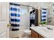 Bright bathroom showcasing blue and white striped shower curtain and vanity with sink at 19560 E 18Th Pl, Aurora, CO 80011