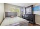 Bedroom features a large window with blinds, dark floors, and grey furniture at 19560 E 18Th Pl, Aurora, CO 80011