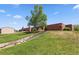 A charming school building with a beautiful large tree on a sunny day at 19560 E 18Th Pl, Aurora, CO 80011