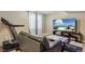 Basement living room with a large sectional, tv, and a pro-form treadmill at 19560 E 18Th Pl, Aurora, CO 80011