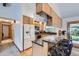 Open kitchen with modern appliances, granite countertops, breakfast bar seating, and hardwood floors throughout at 10602 W Patterson Pl, Littleton, CO 80127