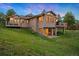 Stunning home boasts a back exterior with expansive windows and a large deck overlooking a lush, green lawn at 2164 Foothills S Dr, Golden, CO 80401