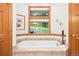 Bathroom featuring a soaking tub with window view and neutral tile surround at 2164 Foothills S Dr, Golden, CO 80401