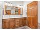 Bathroom featuring a wood vanity with double sinks and a large mirror at 2164 Foothills S Dr, Golden, CO 80401