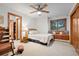 Bright bedroom with ceiling fan, carpet, window seat, and wood-trimmed doors and windows at 2164 Foothills S Dr, Golden, CO 80401