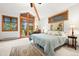 Bright bedroom with neutral carpet, light blue bedding and sitting area at 2164 Foothills S Dr, Golden, CO 80401