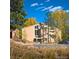 Modern home exterior with unique window design, professional landscaping, and mature trees on a sunny day at 2164 Foothills S Dr, Golden, CO 80401