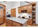 Spacious kitchen island with granite counters, custom cabinets and adjoining dining and office areas at 2164 Foothills S Dr, Golden, CO 80401