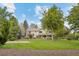 Expansive backyard with lush lawn, mature trees, and basketball court at 560 Front Range Rd, Littleton, CO 80120