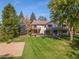 Expansive backyard with lush lawn, mature trees, basketball court, and outdoor seating areas for entertaining and relaxing at 560 Front Range Rd, Littleton, CO 80120