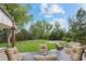 Inviting backyard patio with comfortable seating, a fire pit, and a view of the lush, landscaped yard at 560 Front Range Rd, Littleton, CO 80120