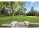 Expansive backyard featuring a lush lawn, mature trees, and a patio area with outdoor seating at 560 Front Range Rd, Littleton, CO 80120