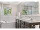 Bright bathroom features dual sinks, dark cabinetry, a large mirror, and modern fixtures at 560 Front Range Rd, Littleton, CO 80120