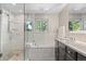 Bright, modern bathroom with glass shower, soaking tub, dual sinks, and tile floors at 560 Front Range Rd, Littleton, CO 80120