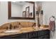 Bathroom featuring granite countertop, vessel sink, dark cabinetry, and decorative accents at 560 Front Range Rd, Littleton, CO 80120