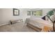 Cozy bedroom with neutral walls, soft carpet, bright window, and comfortable furnishings at 560 Front Range Rd, Littleton, CO 80120