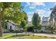 Charming home with a well-manicured lawn, mature trees, and inviting entrance with beautiful landscaping at 560 Front Range Rd, Littleton, CO 80120