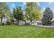 Well-maintained home with a large front lawn and mature trees at 560 Front Range Rd, Littleton, CO 80120
