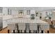 Gourmet kitchen with granite countertops, white cabinets, stainless steel appliances, and a spacious center island with seating at 560 Front Range Rd, Littleton, CO 80120
