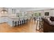 Bright, spacious kitchen with white cabinetry, an island with barstool seating, and hardwood flooring, open to dining area at 560 Front Range Rd, Littleton, CO 80120