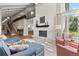 Elegant living room featuring a fireplace, comfortable seating, and a staircase to an upper level balcony at 560 Front Range Rd, Littleton, CO 80120