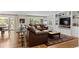 Cozy living room with a comfortable leather sectional, built-in bookshelves, and large windows offering natural light at 560 Front Range Rd, Littleton, CO 80120