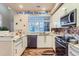 Modern kitchen with white cabinets, granite counters, and stainless steel appliances at 4508 E Louisiana Ave, Denver, CO 80246