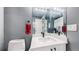 A bathroom with gray walls, white cabinets, modern fixtures, and a toilet at 7865 E Mississippi Ave # 702, Denver, CO 80247