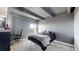 A grey bedroom with a queen bed, white closet doors, exposed ceiling beams, and a window at 7865 E Mississippi Ave # 702, Denver, CO 80247