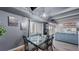 Cozy dining area with a glass-top table, modern chairs, and views of the open-concept living space at 7865 E Mississippi Ave # 702, Denver, CO 80247