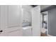 A laundry room with a stacked washer and dryer and white shutter doors for storage at 7865 E Mississippi Ave # 702, Denver, CO 80247