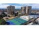 Aerial view showcases pickleball courts and tennis courts, complimented by the buildings and mountain views in the background at 7865 E Mississippi Ave # 702, Denver, CO 80247