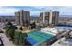 Aerial view shows pickleball court and tennis courts, surrounded by beautifully landscaped grounds with high-rise buildings at 7865 E Mississippi Ave # 702, Denver, CO 80247