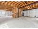 Spacious unfinished basement featuring exposed wooden ceiling beams and ample room for custom renovation at 5021 S Rome St, Aurora, CO 80015