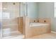 Bathroom featuring glass enclosed walk-in shower and separate soaking tub at 5021 S Rome St, Aurora, CO 80015