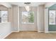 A brightly lit dining room features neutral paint, a modern chandelier, and large windows at 5021 S Rome St, Aurora, CO 80015