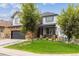 Charming two-story home with an attached garage and lush front lawn at 5021 S Rome St, Aurora, CO 80015