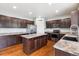 Spacious kitchen featuring dark wood cabinets, stainless steel appliances, and a center island at 5021 S Rome St, Aurora, CO 80015