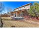 Backyard with a covered patio, seating, grill, landscaped yard, and mature trees at 5128 Longs Peak St, Brighton, CO 80601