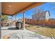 Covered patio with a grill, landscaping, a seating area, and mature trees at 5128 Longs Peak St, Brighton, CO 80601