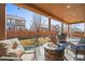 Covered patio with a stone fire pit, comfortable seating, and a view of the landscaped yard at 5128 Longs Peak St, Brighton, CO 80601