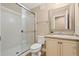 Neat bathroom with a white shower, glass door, white toilet, and vanity with framed mirror at 5128 Longs Peak St, Brighton, CO 80601