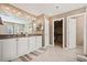 Bathroom with double vanity and doorway into a walk-in closet at 5128 Longs Peak St, Brighton, CO 80601