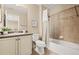 Well-lit bathroom with neutral-toned tiled shower-tub combo and neutral vanity at 5128 Longs Peak St, Brighton, CO 80601