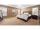Spacious bedroom with carpet flooring, large window, and a dark wood bed frame at 5128 Longs Peak St, Brighton, CO 80601
