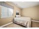 Cozy bedroom with neutral walls, window with blinds, plush carpet, and a comfortable bed at 5128 Longs Peak St, Brighton, CO 80601